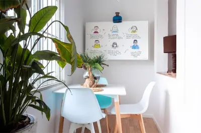 a dining room with a white table and a plant at Studio Faria Guimaraes in Porto