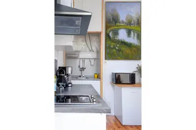 a kitchen with a sink and a painting on the wall at Studios Faria Guimaraes in Porto