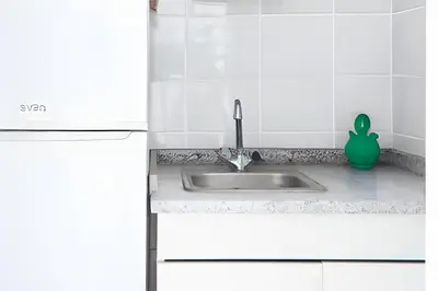 a kitchen sink with a green detergent next to it at Studios Faria Guimaraes in Porto