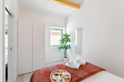 a white room with a bed with a tray of food at Bright Flat | Romantic Escape by HostWise in Porto