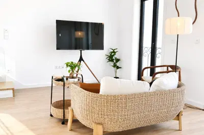 a living room with a wicker chair and a tv at AC, 2Bedrooms APT, City Center 900m to Metro in Porto