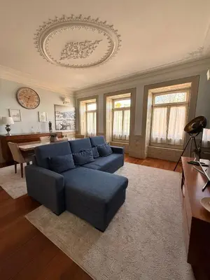 a living room with a blue couch and a piano at Alegria Vintage Apartments - Porto in Porto