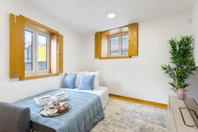 a living room with a bed and a couch at Modern & Central Flat w/ Garage by HostWise in Porto