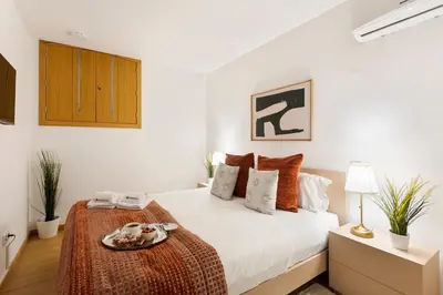 a white bedroom with a bed with a tray on it at Modern & Central Flat w/ Garage by HostWise in Porto
