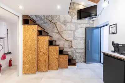 a room with wooden doors and a stone wall at Lapa 4 House in Porto