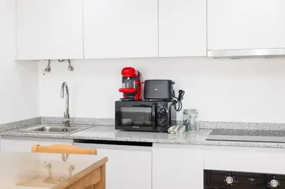 a kitchen counter with a microwave and a coffee maker at Cozy Studios Porto Sao Lazaro in Porto