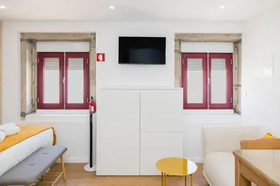 a living room with a bed and a tv at Cozy Studios Porto Sao Lazaro in Porto