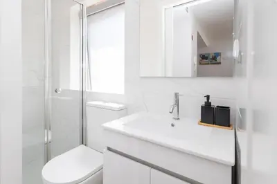a white bathroom with a sink and a mirror at Cozy Studios Porto Sao Lazaro in Porto