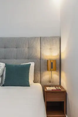 a bedroom with a bed and a lamp on a night stand at Urban Oasis Six Suites Apts Porto in Porto
