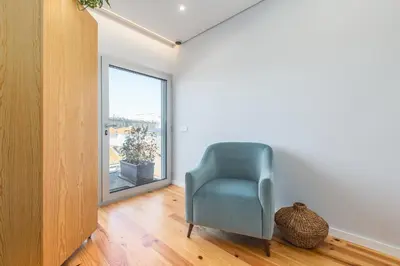 a blue chair in a room with a window at Urban Oasis Six Suites Apts Porto in Porto