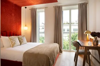 a bedroom with a bed and a desk and windows at Sa Bandeira Signature Apartment in Porto