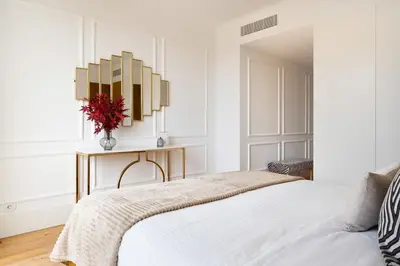 a white bedroom with a bed and a vase of flowers at Sa Bandeira Signature Apartment in Porto