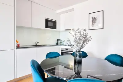 a dining room with a glass table and blue chairs at 89 T3 - Flores Gem in Porto