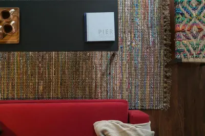 a red couch in front of a wall with a curtain at Oporto Serviced Apartments - Cedofeita in Porto