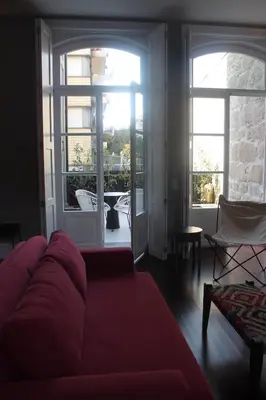a living room with a red couch and windows at Oporto Serviced Apartments - Cedofeita in Porto