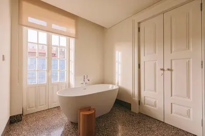 a white bath tub in a bathroom with a window at LENSCAPE Coterie in Porto