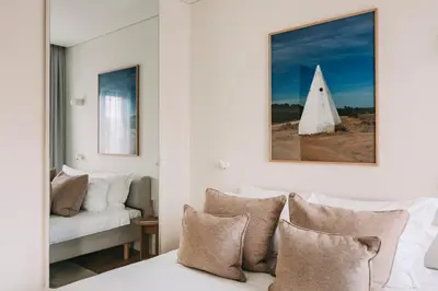 a bedroom with a couch and a bed with pillows at LENSCAPE Coterie in Porto