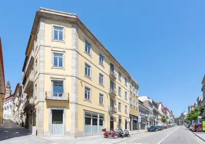 a yellow building on the side of a street at Centro Histórico Porto- São Bento Station in Porto