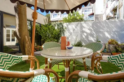 a table with chairs and an umbrella on a patio at Garden Luxury House Downtown Oporto with AC in Porto