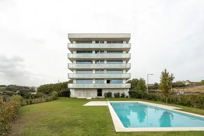 a house with a swimming pool in front of a building at Premium Apartments with Balcony, Pool & Garage by HostWise in Vila Nova de Gaia