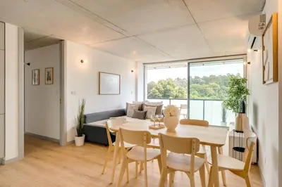 a living room with a table and chairs and a couch at Premium Apartments with Balcony, Pool & Garage by HostWise in Vila Nova de Gaia