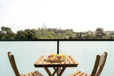 a table with a bowl of fruit on a balcony at Premium Apartments with Balcony, Pool & Garage by HostWise in Vila Nova de Gaia