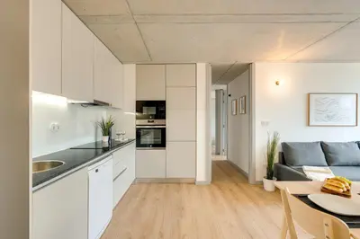 a kitchen and living room with a couch and a table at Premium Apartments with Balcony, Pool & Garage by HostWise in Vila Nova de Gaia