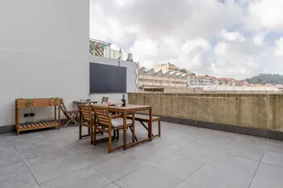 a room with a table and chairs on a balcony at Modern & Sleek Flat | Terrace & Garage by HostWise in Porto