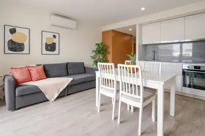 a living room with a couch and a table and chairs at Modern & Sleek Flat | Terrace & Garage by HostWise in Porto