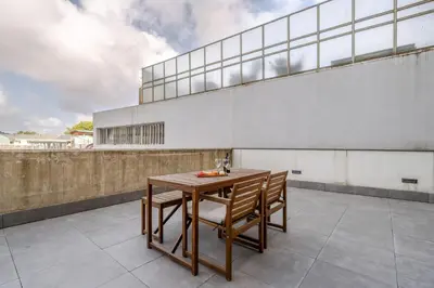a wooden table and chairs on a balcony at Modern & Sleek Flat | Terrace & Garage by HostWise in Porto