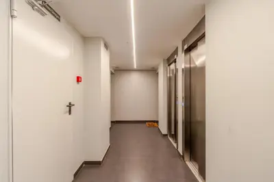 a hallway with white walls and a cross on the wall at Modern & Sleek Flat | Terrace & Garage by HostWise in Porto