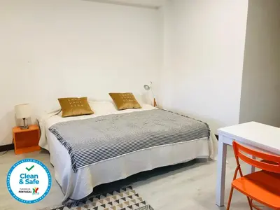 a bedroom with a bed and a table and a chair at In Love Bolhão in Porto