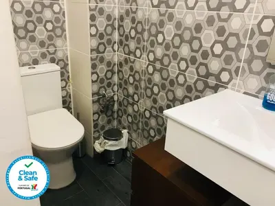 a bathroom with a white toilet and a sink at In Love Bolhão in Porto
