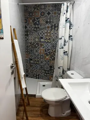 a bathroom with a toilet and a shower curtain at Simple House in the Heart of the Historic Center in Porto