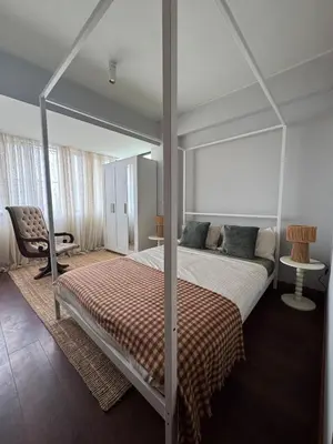 a bedroom with a canopy bed and a chair at Casa da Música Apartment in Porto