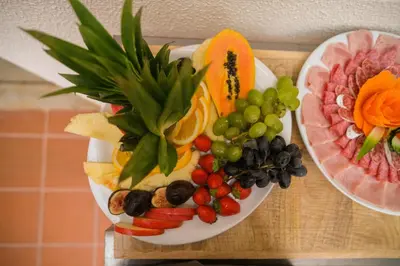 a plate of fruit and vegetables on a table at Porto Surf Lodge in Porto