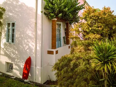 a white house with a window and plants at Porto Surf Lodge in Porto
