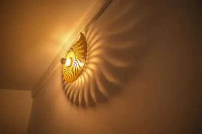 a light on a wall with a mask on it at Porto Surf Lodge in Porto