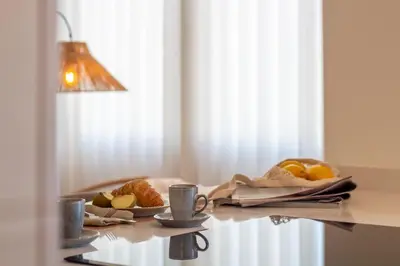 a table with cups of coffee and fruit on it at Peaceful 1BR Near Metro by LovelyStay in Porto