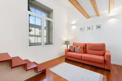 a living room with a orange couch and a window at GuestReady - Lovely nook with mezzanine in Porto
