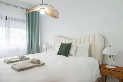 a bedroom with a white bed with towels on it at Purely Porto in Porto