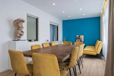 a dining room with a wooden table and yellow chairs at Purely Porto in Porto