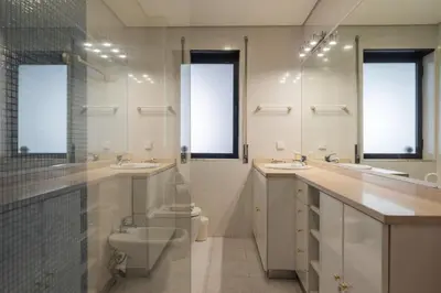 a bathroom with two sinks a toilet and two mirrors at Purely Porto in Porto