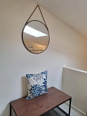 a mirror hanging on a wall with a bed in a room at My 2ndHome Porto Villa in Porto