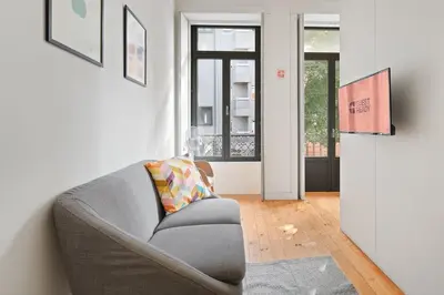 a living room with a gray chair and a window at GuestReady - Homely experience in Porto in Porto