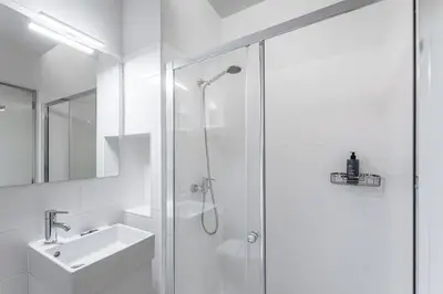 a white bathroom with a shower and a sink at GuestReady - Homely experience in Porto in Porto
