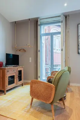 a living room with a chair and a television at Oliveirinhas Boutique Flats in Porto