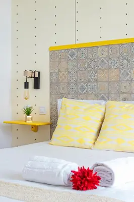 a white bed with a red flower on top of it at St Catarina Flats in Porto