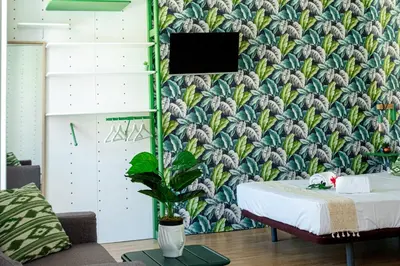 a bedroom with a wall with a tropical wallpaper at St Catarina Flats in Porto