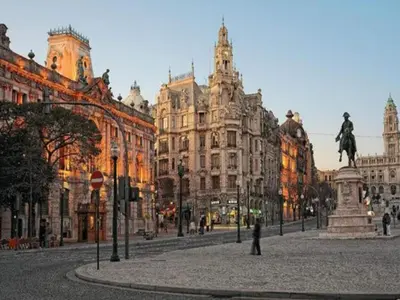 a city street with a statue in front of buildings at Porto Stay for 3 near Ribeira in Porto
